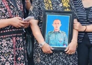 Keluarga memegang foto alm Prada Lucky saat pengebumian.(simantab/ist)