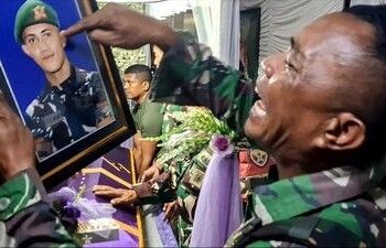 Ayah Prada Lucky Chepril, Serma Kristian Namo Saputra Namo menangis memandang foto anaknya.(simantab/ist)