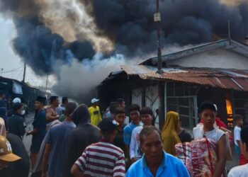 Pedagang dan warga hanya bisa pasrah menyaksikan api melahap kios di Pasar Serbelawan.(simantab/putra purba)