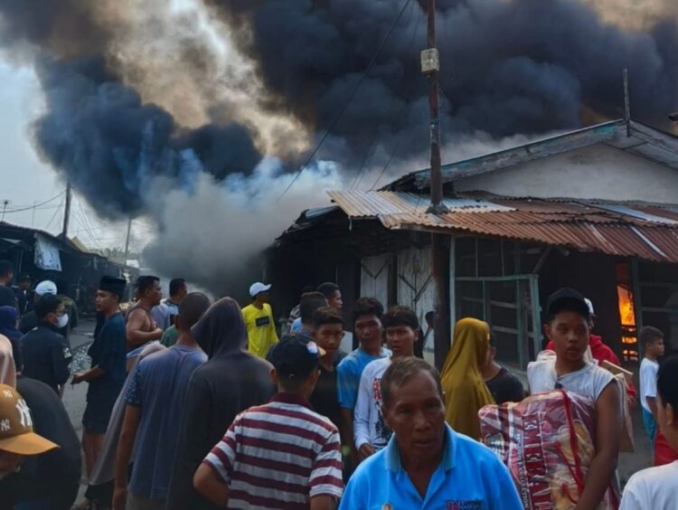 Pedagang dan warga hanya bisa pasrah menyaksikan api melahap kios di Pasar Serbelawan.(simantab/putra purba)
