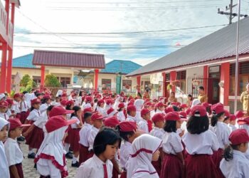 Guru SD Negeri 122390, di jalan Bahagia No 3, Kelurahan Kristen, Kecamatan Siantar Selatan, Pematangsiantar membagikan lembar kerja kepada siswa. Sekolah terpaksa diliburkan sebagai antisipasi adanya demonstrasi.(Simantab/Putra Purba)