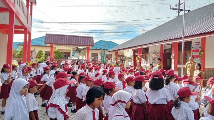 Guru SD Negeri 122390, di jalan Bahagia No 3, Kelurahan Kristen, Kecamatan Siantar Selatan, Pematangsiantar membagikan lembar kerja kepada siswa. Sekolah terpaksa diliburkan sebagai antisipasi adanya demonstrasi.(Simantab/Putra Purba)