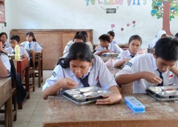Pelajar SMP Negeri 7 Pematangsiantar menikmati sajian Makan Bergizi Gratis (MBG) di ruang kelas.(Putra Purba)