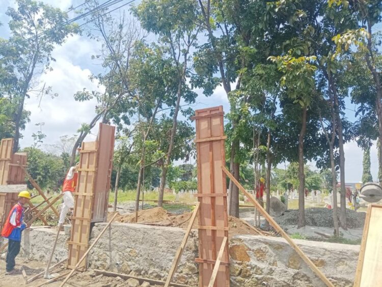 Beberapa pekerja sedang melakukan pembangunan pagar beton di Proyek rehabilitasi Makam Pahlawan Siantar.(Simantab/Putra Purba)