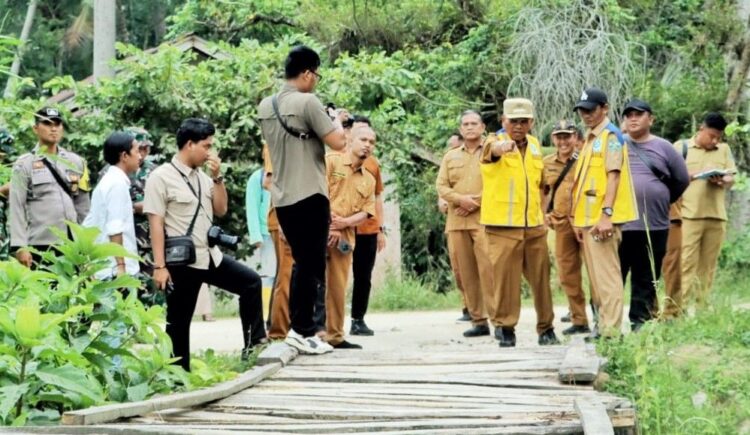 Bupati Simalungun Anton Achmad Saragih menunjuk satu jembatan rusak di Kecamatan Ujung Padang.(Simantab/ist)