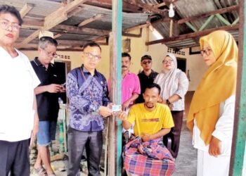 Zuang Al Chabid (duduk di kursi), warga Amansari mendapat bantuan Pemerintah Kabupaten Simalungun berupa identitas diri (KTP) dan BPJS.(Simantab/ist)