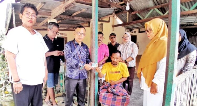 Zuang Al Chabid (duduk di kursi), warga Amansari mendapat bantuan Pemerintah Kabupaten Simalungun berupa identitas diri (KTP) dan BPJS.(Simantab/ist)