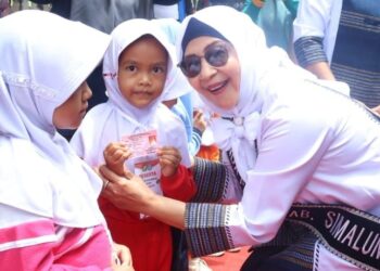 Ketua TP PKK Simalungun, Darmawati Anton Achmad Saragih, dengan salah seorang anak PAUD.(Simantab/ist)