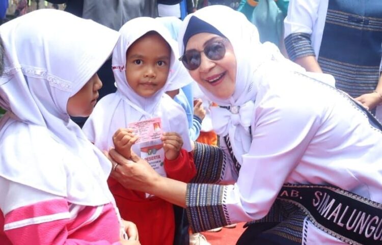 Ketua TP PKK Simalungun, Darmawati Anton Achmad Saragih, dengan salah seorang anak PAUD.(Simantab/ist)