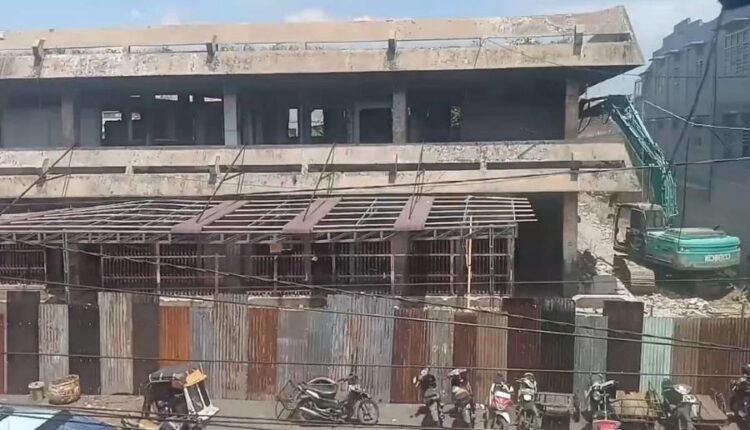 Pekerjaan perobohan eks Gedung IV Pasar Horas tampak berlangsung di tengah padatnya aktivitas masyarakat dan lalu lintas di kawasan pasar.(Simantab/Putra Purba)