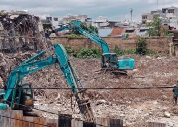 Dua unit ekskavator bekerja merobohkan sisa struktur beton Gedung IV Pasar Horas yang hangus terbakar tahun lalu.(Simantab/Putra Purba)