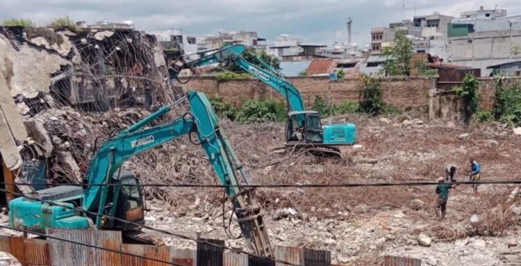 Dua unit ekskavator bekerja merobohkan sisa struktur beton Gedung IV Pasar Horas yang hangus terbakar tahun lalu.(Simantab/Putra Purba)