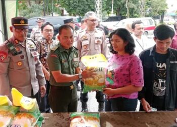 Seorang warga menerima paket beras murah SPHP dari operasi pasar yang digelar Polres Pematangsiantar, TNI bersama Bulog, sebagai upaya menjaga stabilitas harga pangan di Pematangsiantar.(Simantab/Putra Purba)