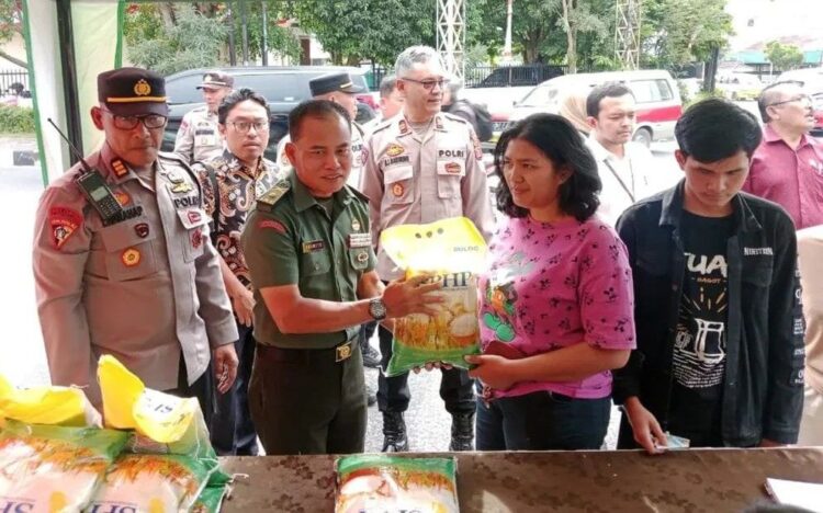 Seorang warga menerima paket beras murah SPHP dari operasi pasar yang digelar Polres Pematangsiantar, TNI bersama Bulog, sebagai upaya menjaga stabilitas harga pangan di Pematangsiantar.(Simantab/Putra Purba)