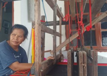 L Siregar (45), penenun ulos di Jalan Aries 1, Bah Kapul, masih setia menenun secara mandiri di teras rumahnya.(Simantab/Putra Purba)