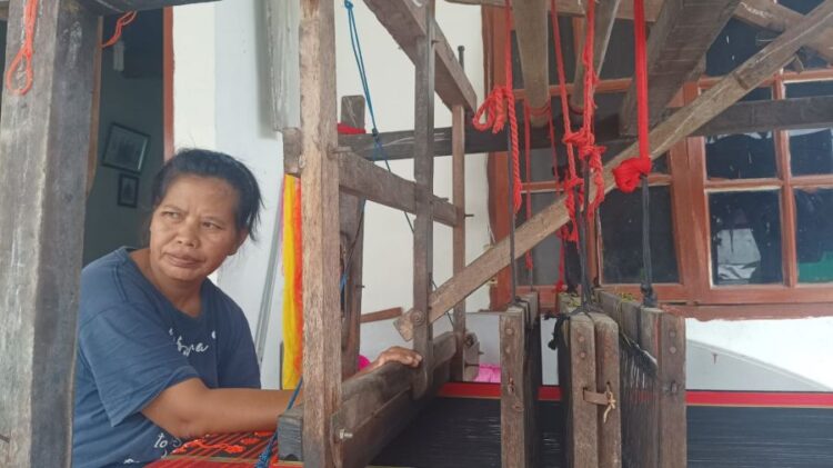 L Siregar (45), penenun ulos di Jalan Aries 1, Bah Kapul, masih setia menenun secara mandiri di teras rumahnya.(Simantab/Putra Purba)