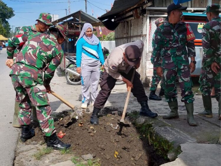 Camat Dolok Batunanggar, Siti Aminah Siregar (baju olahraga), bersama personel Koramil Serbelawan, Polsek, dan warga bergotong royong membersihkan parit di Kelurahan Aman Sari, Kecamatan Dolok Batunanggar, Simalungun.(Simantab/ist)