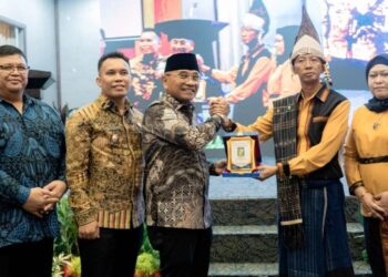 Bupati Simalungun Anton Achmad Saragih memberi plakat sebagai cindramata kepada Irfan Hergianto.(Simantab/ist)