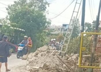 Tumpukan material dan sisa galian masih terlihat di sisi jalan, mempersulit pengguna jalan.(Simantab/Putra Purba)