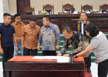 Ketua DPRD Kota Pematangsiantar, Timbul M Lingga menandatangani persetujuan APBD TA 2026 di Gedung Harungguan DPRD, Jalam Adam Malik, Kota Pematangsiantar. Sabtu (29/11/2025) malam. (Simantab/ist)