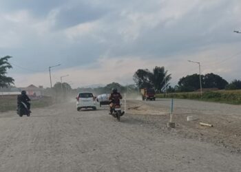 Sejumlah pengendara melintas di ruas Jalan Outer Ringroad Siantar yang tengah dalam tahap pengerasan base course.(Simantab/Putra Purba)